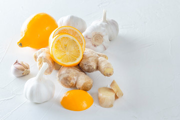 Ginger, garlic and lemon - a means to protect against viral infection and colds on a light wooden table. Copy space