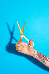 Tattooed hand using scissors