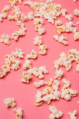 popcorn is scattered on a pink background