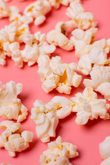 popcorn is scattered on a pink background