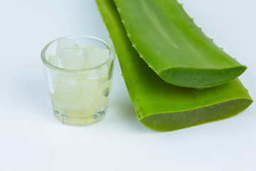 Jel of aloe vera in a glass with aloe vera leave is near together on white background.