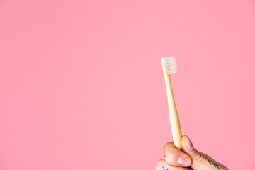 Yellow toothbrush on a pink background