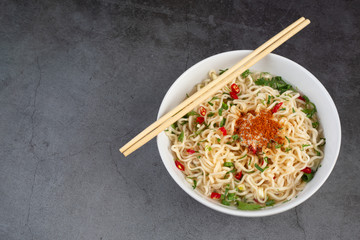 Instant noodle ready to eat with chopsticks in cup  on black background.