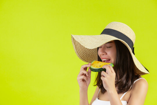 Sexy Girl Is Eating Watermalon In Sumer Hot Weather With Hat On Yellow Background.