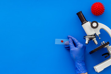 Coronavirus vaccine, research with microscope. Blue background top view copy space