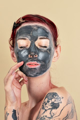 Woman doing a black charcoal mask
