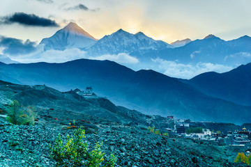  Muktinath village, layers of hills and setting sun behind Dhaulagiri Mountain in an evening seen...