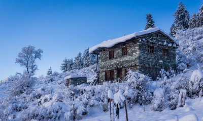 a house made iwth stone in the high mountain region of Nepal, in Mugu, Karnali, Nepal. The village is covered with fresh snowfall in the beginning of spring season. Nepali architecture.