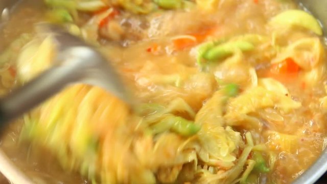 Cooking tamarind sour soup with agasta or Kang som , Thai famous food