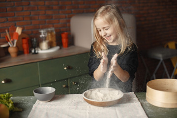 Little girl prepare the pie. Kid in the kitchen. Child with a flour.