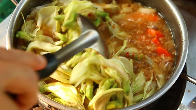 Cooking tamarind sour soup with agasta or Kang som , Thai famous food