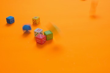 Cube with numbers.Bouncing dice. Multicolored cubes  on a bright green orange background. Numbers and symbols. Figure 4. Board game. Chaos. The same amount. Luck and luck.