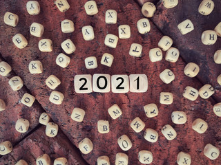 Time and year concept. 2021 written on wooden blocks. Vintage styled background.
