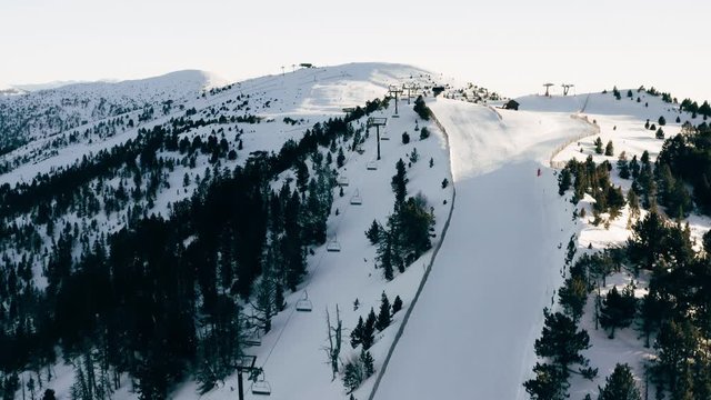 Aerial view of the ski slope and the snowy peaks of the mountains against the blue sky, Andorra