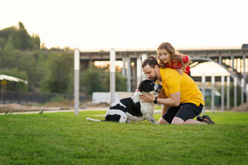 Happy family on summer walk. Dad, daughter and hunting dog have fun in park and playing together. Friendship between owner and pet. Funny expressive leisure time. Faithful friends of human.