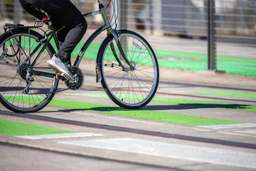 Fototapeta na wymiar Cyclist in sportswear crosses tram tracks on a dedicated crossing for cyclists and pedestrians