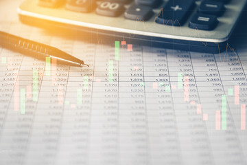 Pen and Calculator on accounting report with trading graph, Business and Financial concept. 