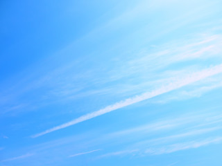 青空の下の筋雲と飛行機雲