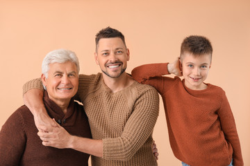 Man with his father and son on color background
