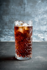 Cold cola beverage in glass with ice. Selective focus. Shallow depth of field.