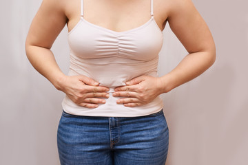Woman menstruation pain. Hold hand near body. Self chiropractic massage. jeans and top shirt. Nerve...