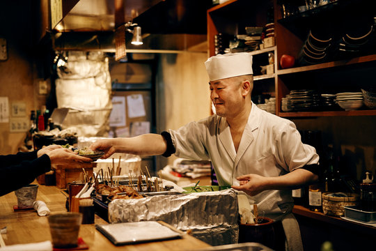お客さんと会話をする笑顔の料理人