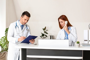 Fototapeta premium Female medical assistant with doctor in clinic