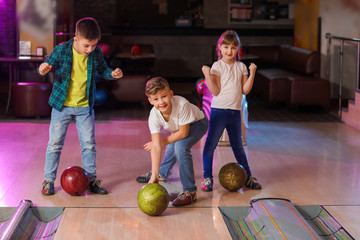 Fototapeta premium Little children playing bowling in club