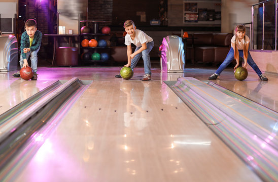 Little children playing bowling in club
