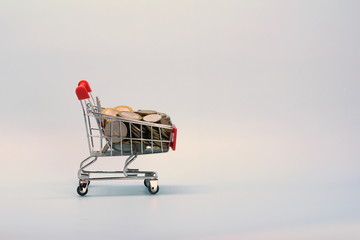 Shopping cart with Russian money. Metal coins and a souvenir shopping basket.