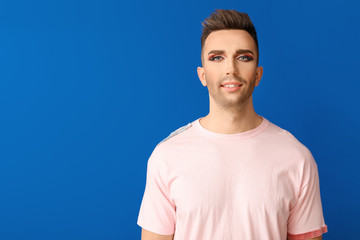 Portrait of young transgender woman on color background