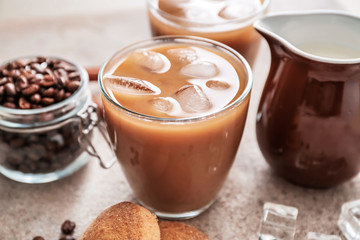 Glass of tasty iced coffee with milk on grey background