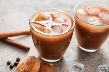 Glasses of tasty iced coffee on grey background