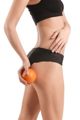 Young woman with orange fruit on white background. Concept of cellulite