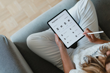 Woman using a stylus with a digital tablet mockup during coronavirus quarantine at home