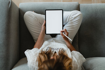 Woman using a stylus with a digital tablet during coronavirus quarantine at home