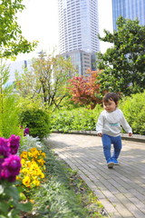 オフィス街に咲く花を見る子供