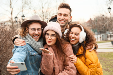 Happy friends taking selfie outdoors