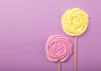 yellow and pink Rose candy   in pastel colors on a wooden stick on a grey  background, Valentine, Mother's Day.
