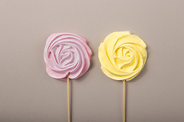 Pink, yellow Rose candy in pastel colors on a wooden stick on a grey  background, Valentine, Mother's Day. 