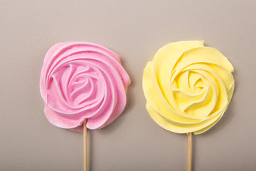 Pink, yellow Rose candy in pastel colors on a wooden stick on a grey  background, Valentine, Mother's Day.