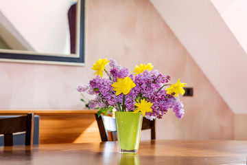 Bouquet of Purple Lilac and Yellow Narcissus on a  Wooden Table .Spring Home Decoration 
