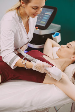 Beautician Giving Epilation Laser Treatment To Woman under the arm