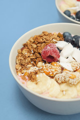 Handmade Bowl healthy tasty breakfast of yogurt, smoothie with granola, nuts, bananas and berries