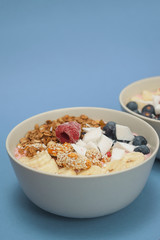 Handmade Bowl healthy tasty breakfast of yogurt, smoothie with granola, nuts, bananas and berries