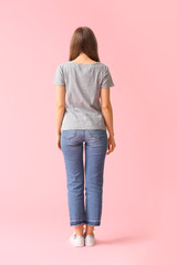 Naklejka premium Young woman in stylish t-shirt on color background