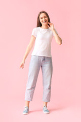 Fototapeta premium Young woman in stylish t-shirt on color background
