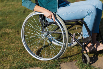 Close up of a young woman in a wheelchair while walking in a park on a sunny day. Recovery and...
