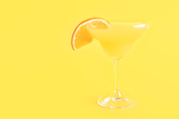 Glass of tasty mimosa cocktail on color background