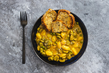 plant-based food, vegan potato gnocchi with nutritional yeast sauce and broad beans